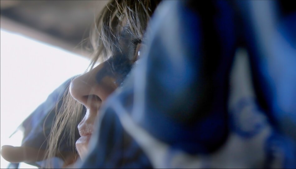 Na zdjęciu twarz kobiety pomalowana na niebiesko.