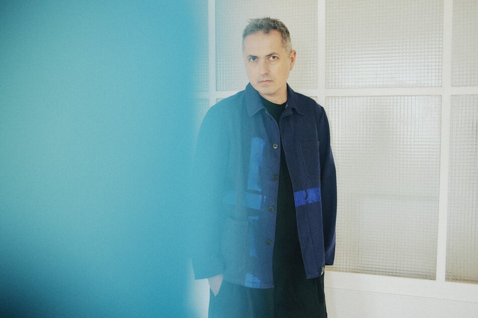 Na zdjęciu mężczyzna w granatowej koszuli, patrzący w lewo.