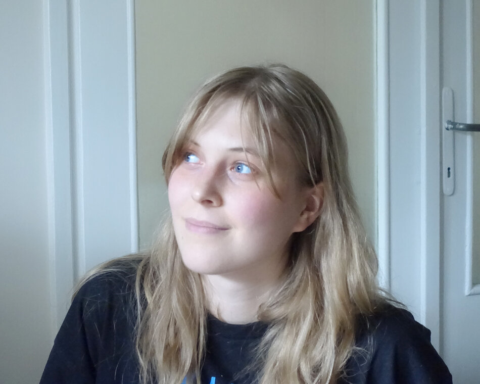 Na zdjęciu kobieta w rozpuszczonych blond włosach, patrząca się w prawo.