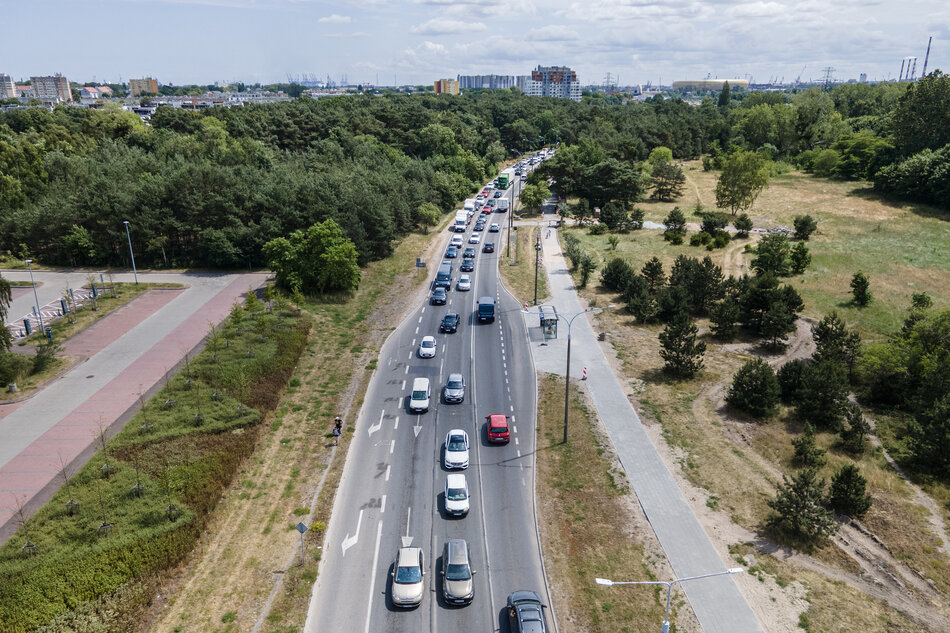 Zdjęcie przedstawia korek drogowy na ul. Jana Pawła II w Gdańsku, w rejonie skrzyżowania z ul. Czarny Dwór – czyli okolice prowadzące w stronę plaży w Brzeźnie oraz Parku Reagana.