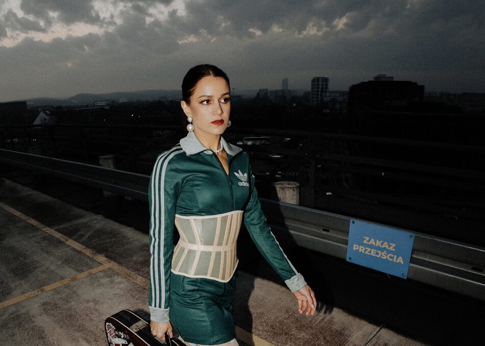 Na zdjęciu kobieta w obcisłym stroju sportowym w kolorze zielonym.