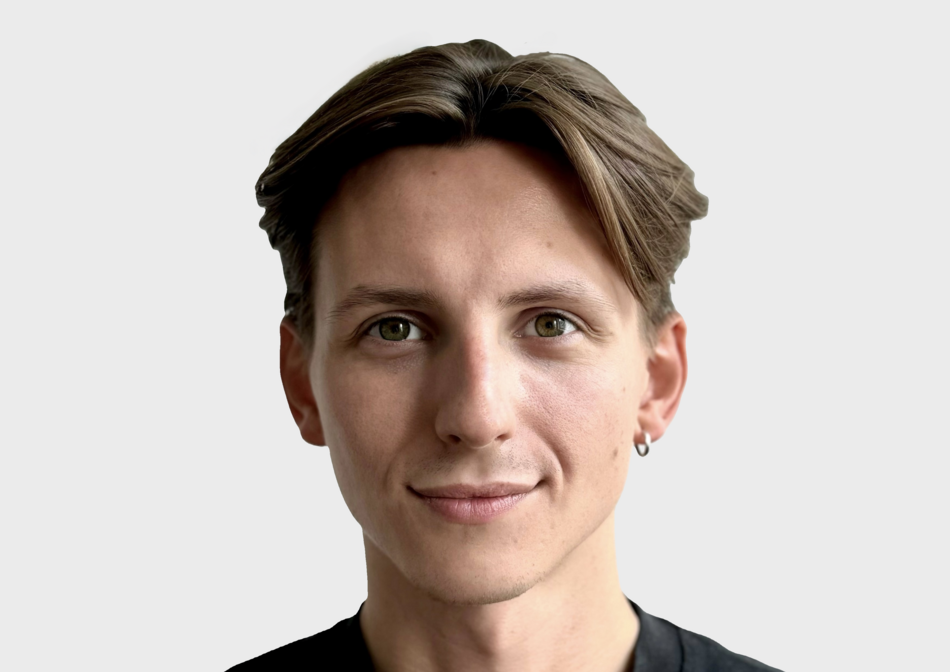 Na zdjęciu twarz uśmiechniętego mężczyzny z krótkimi włosami.