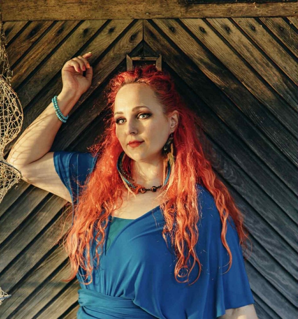 Na zdjęciu kobieta z długimi włosami, na sobie ma sukienkę.