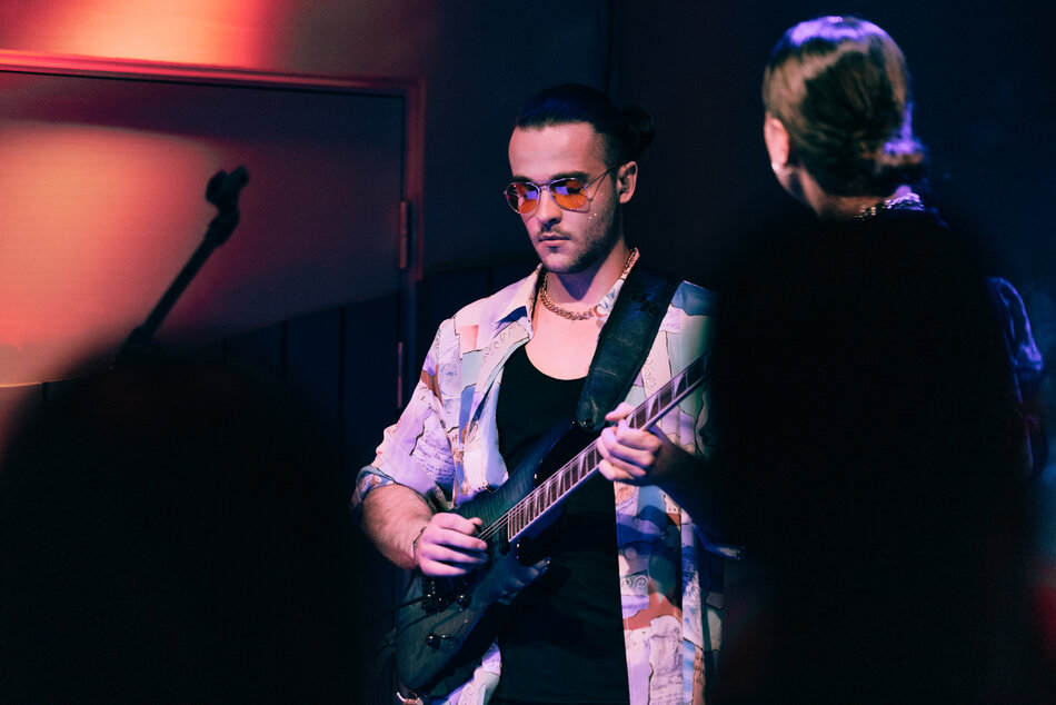 Na zdjęciu mężczyzna grający na gitarze.