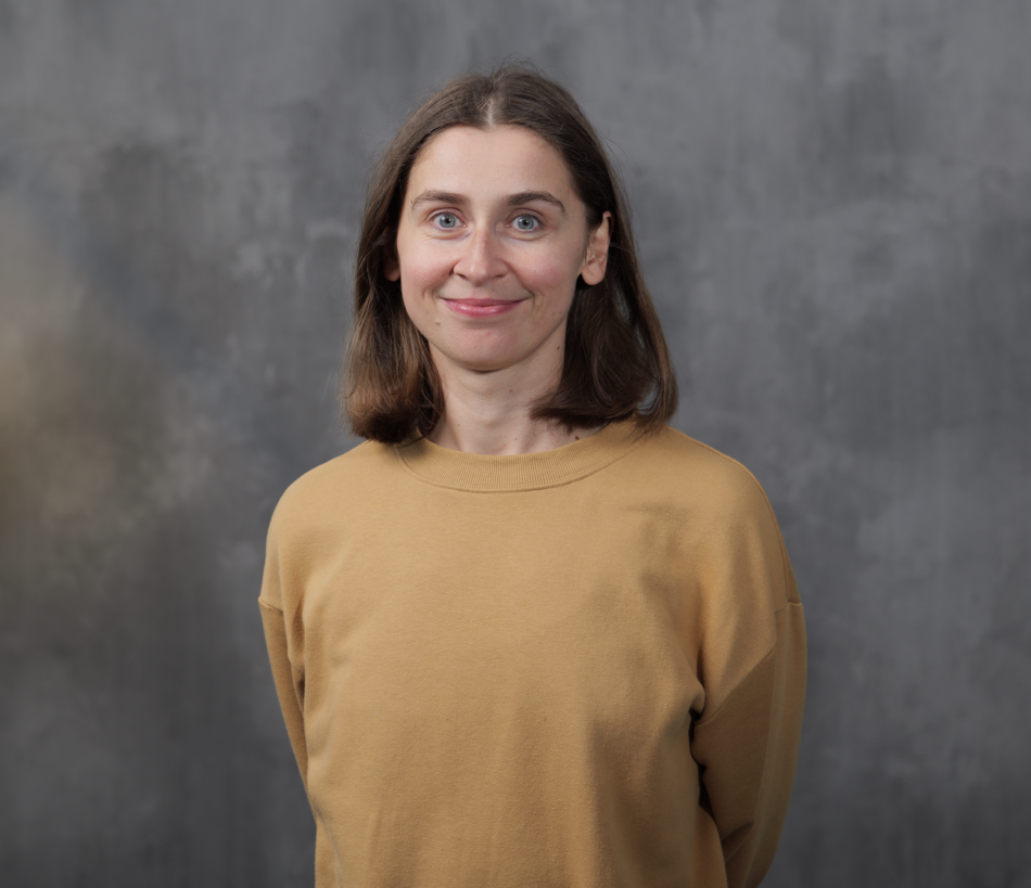 Na zdjęciu młoda uśmiechnięta kobieta w żółtej koszulce z długim rękawem.