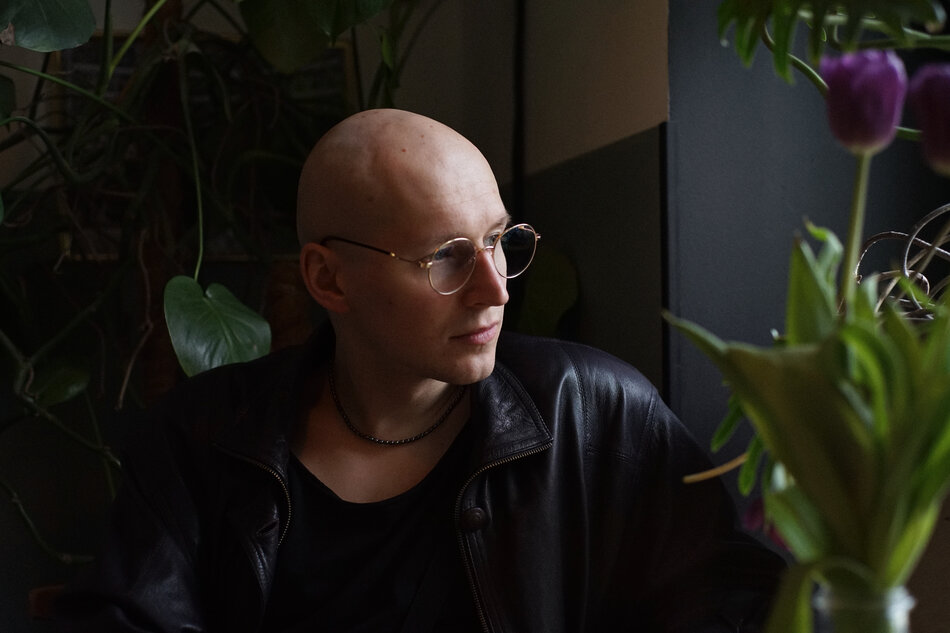 Na zdjęciu łysy mężczyzna w okularach.