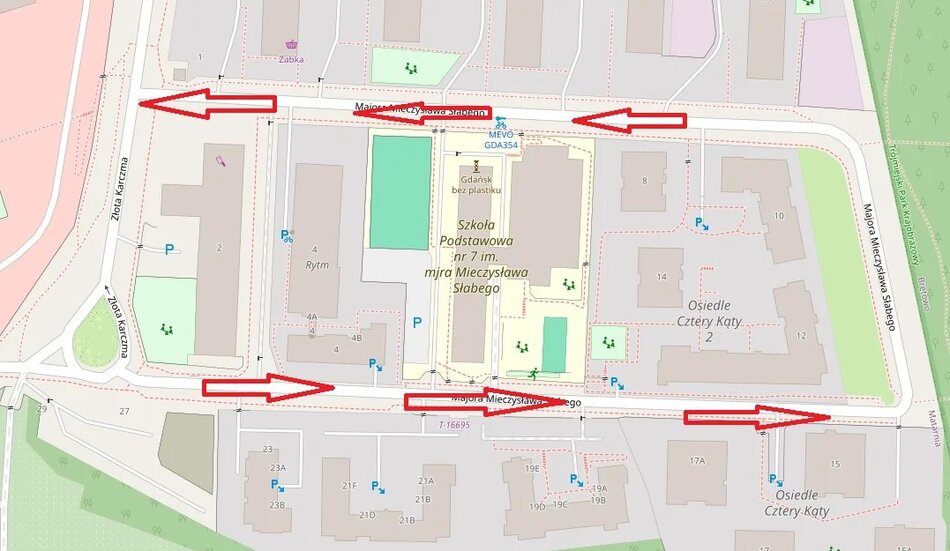 Na mapie widać fragment dzielnicy z zaznaczonym budynkiem Szkoły Podstawowej nr 1 im. mjra Mieczysława Słabego w Gdańsku. Czerwone strzałki pokazują kierunki ruchu jednokierunkowego wokół szkoły i osiedli sąsiednich.