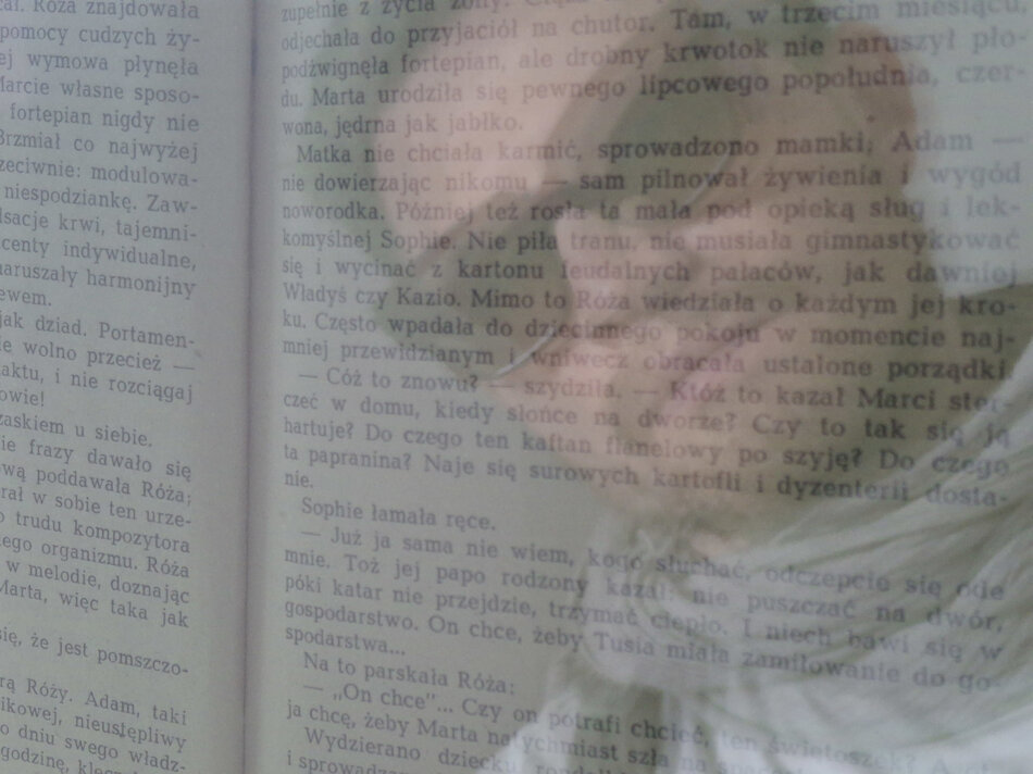 Na zdjęciu mężczyzna w okularach przeciwsłonecznych, na tle rozmytego tekstu książki. 