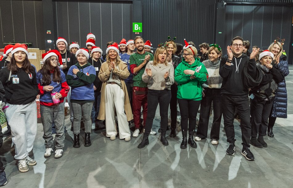 Grupa uśmiechniętych osób w czapkach św. mikołaja