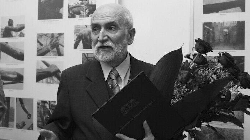 Zdjęcie sędziwego mężczyzny z siwą brodą, jest uczestnikiem uroczystości, trzyma wiązankę kwiatów, które otrzymał razem z nagrodą prezydenta Gdańska