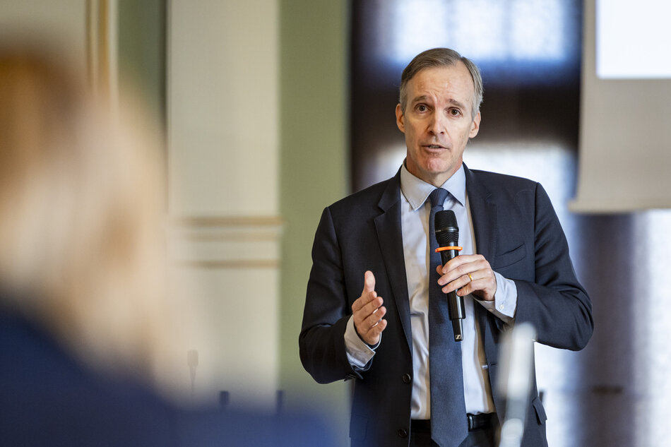 mężczyzna w średnim wieku przemawia do mikrofonu