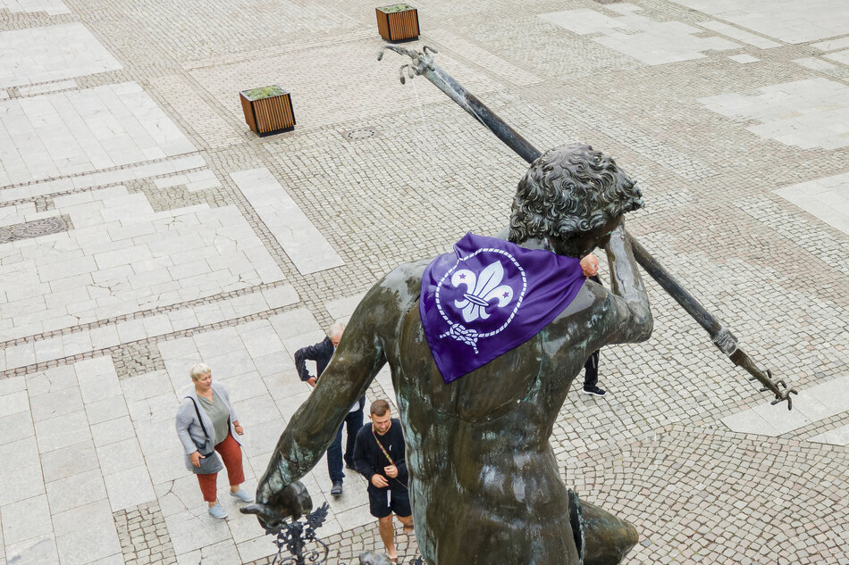 Fioletowa chusta ze znakiem ZHP na plecach rzeźby Neptuna 