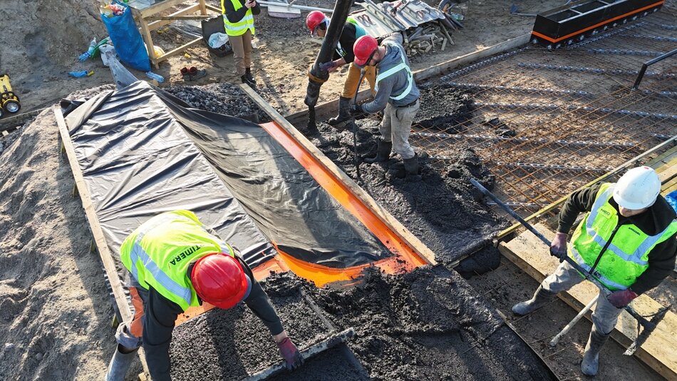 na zdjęciu robotnicy betonują elementy konstrukcji