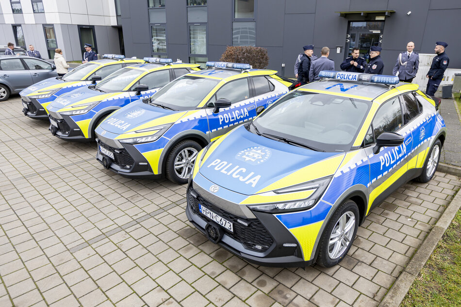 cztery nowoczesne radiowozy policyjne stoją na parkingu przed budynkiem