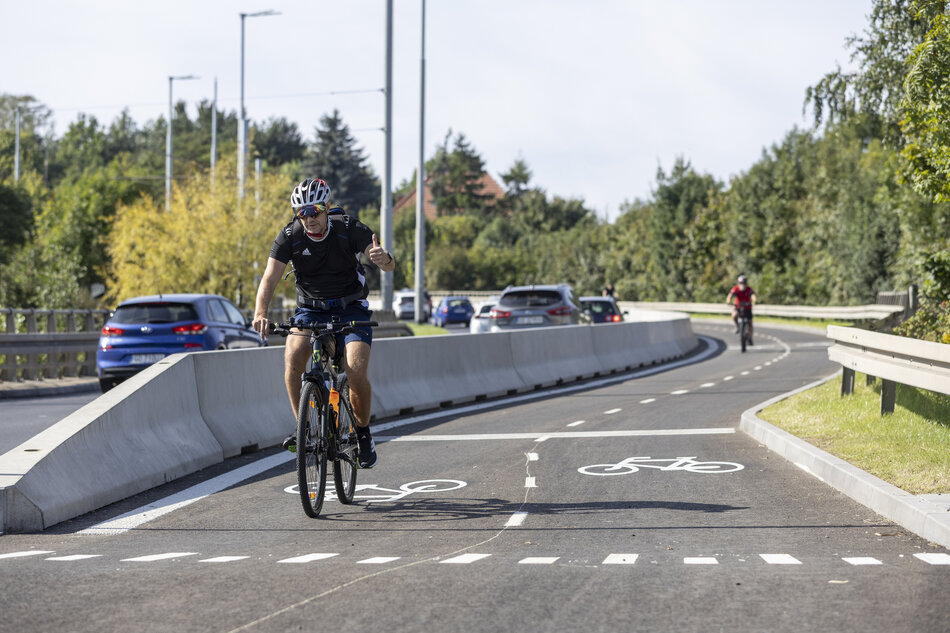 na zdjęciu mężczyzna jadący na rowerze, z kaskiem na głowie