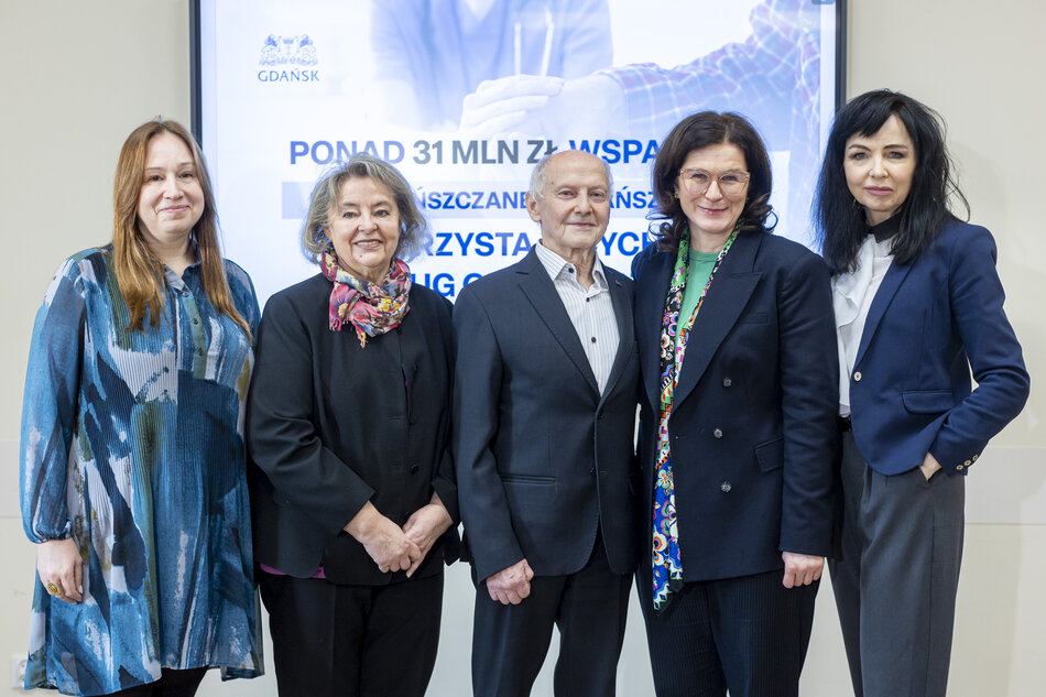 Cztery kobiety i jeden mężczyzna pozują do zdjęcia.