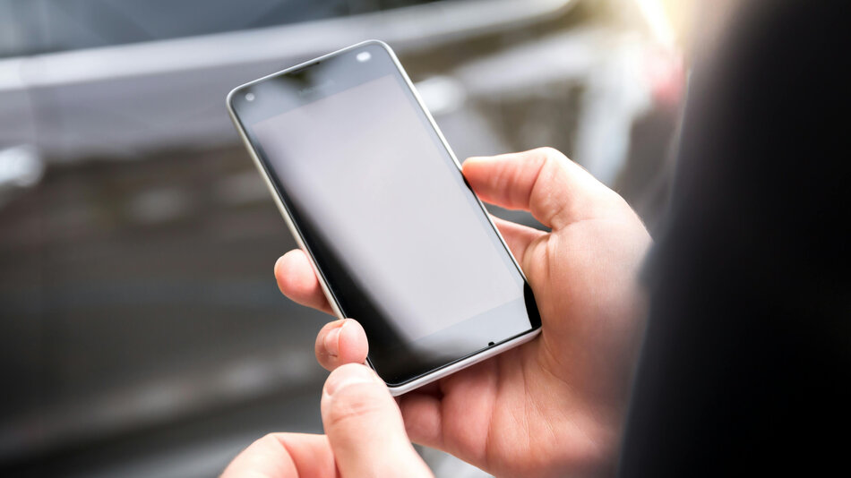 Ręka trzymająca telefon komórkowy.