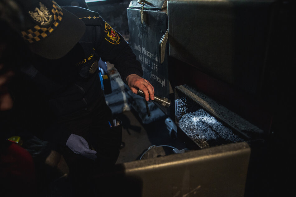 Strażnik miejski sprawdza kocioł grzewczy.