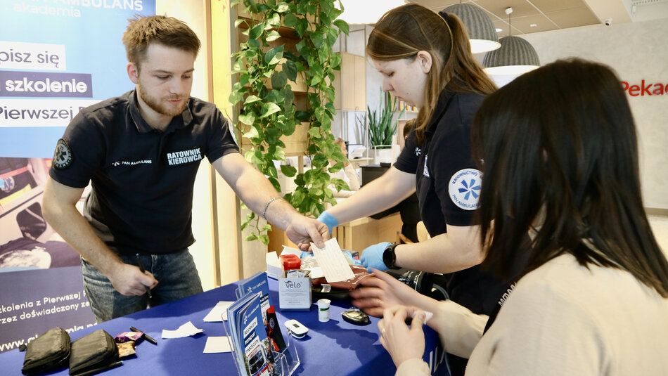 Mężczyzna i kobieta stoją przy stole z niebieskim obrusem
