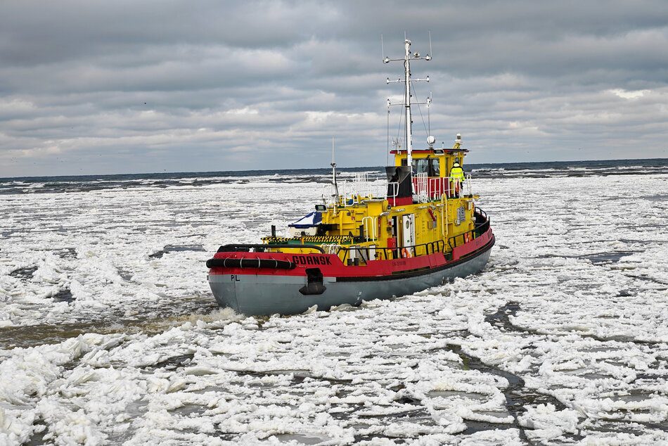 Lodołamacz płynie po zamarzniętej rzece.
