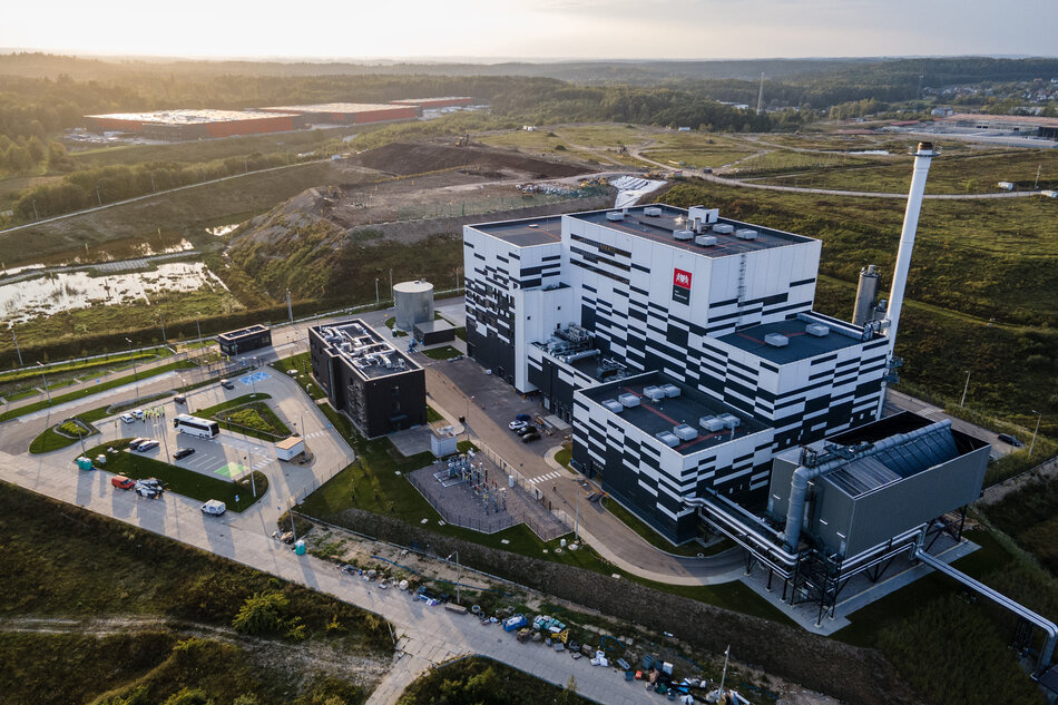 Duży budynek przemysłowy o czarno-białym wzorcu kraterowym. Budynek ma wiele poziomów i wysoki komin po prawej stronie