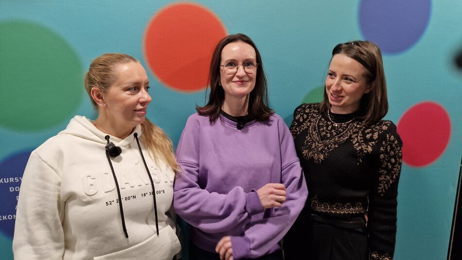 Trzy panie na tle tablicy Fundacja NOVA