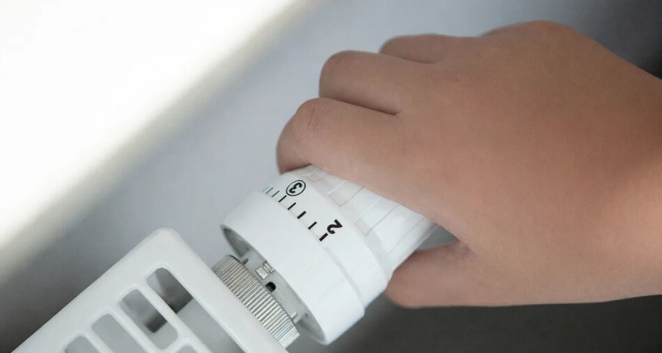 na zdjęciu fragment grzałki od kaloryfera na której kładzie się ludzka dłoń