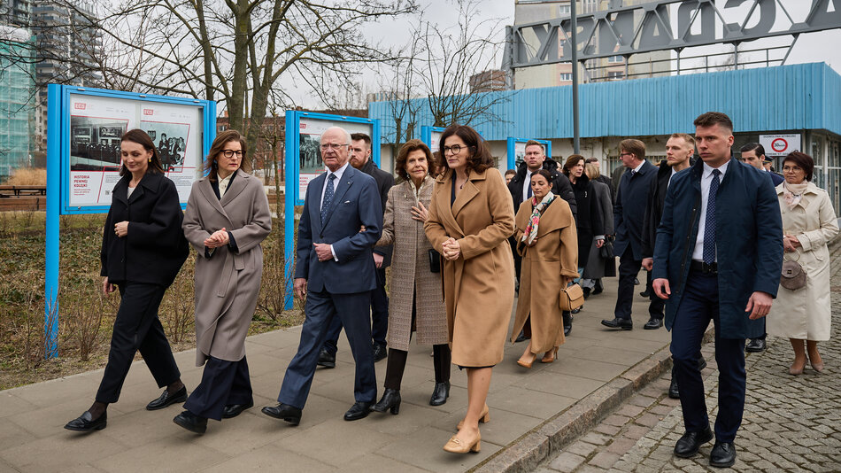 grupa osób w oficjalnych strojach idą przed siebie