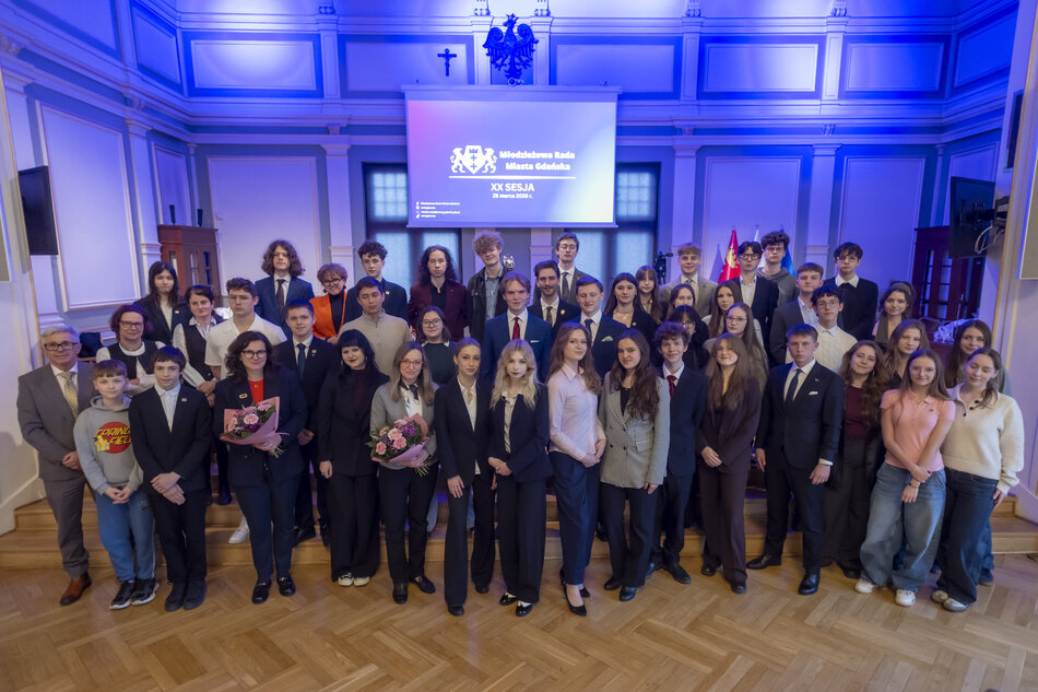 Grupowe pamiątkowe zdjęcie, pozuje ponad czterdzieści osób, głównie nastolatki, wszyscy elegancko ubrani