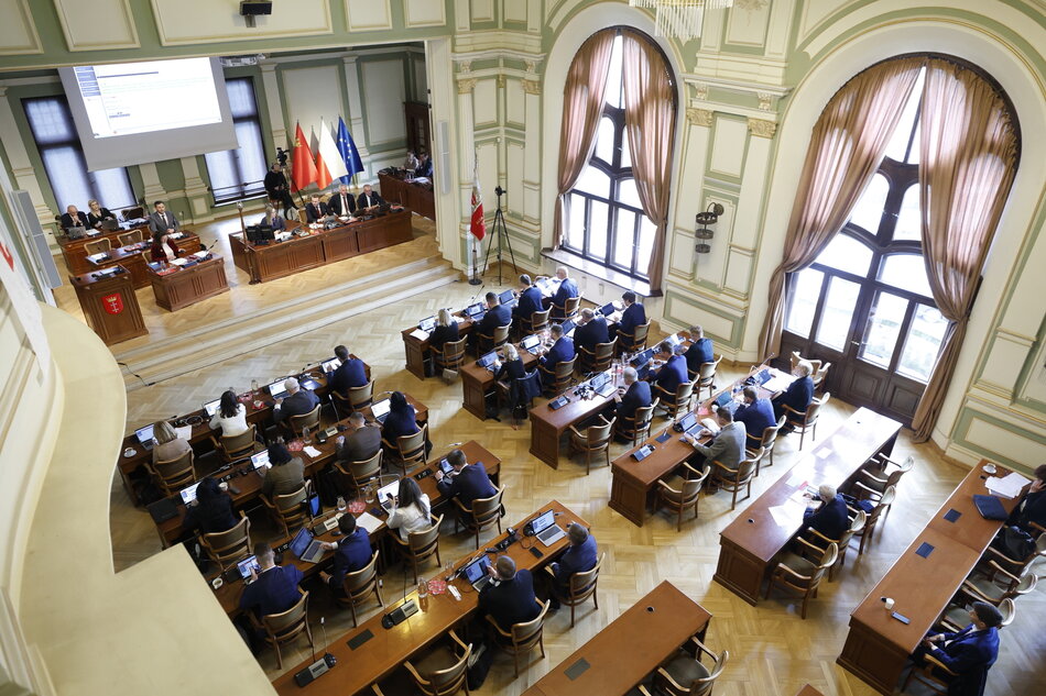 Sala obrad pokazana z góry, z galerii dla publiczności. Radni siedzą w dole przy ławach