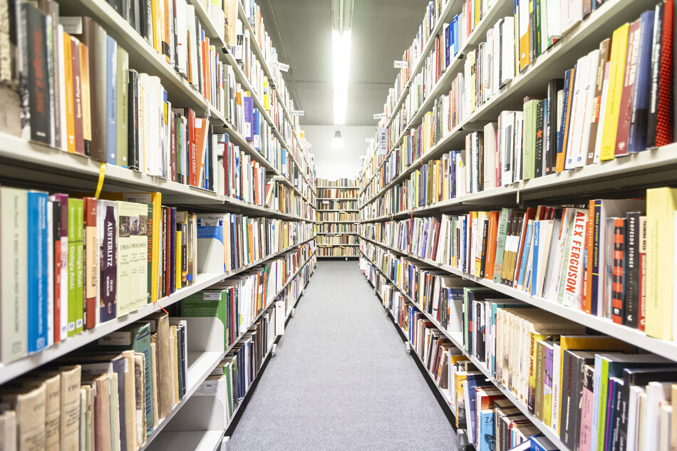 na zdjęciu regały w bibliotece wypełnione po brzegi książkami