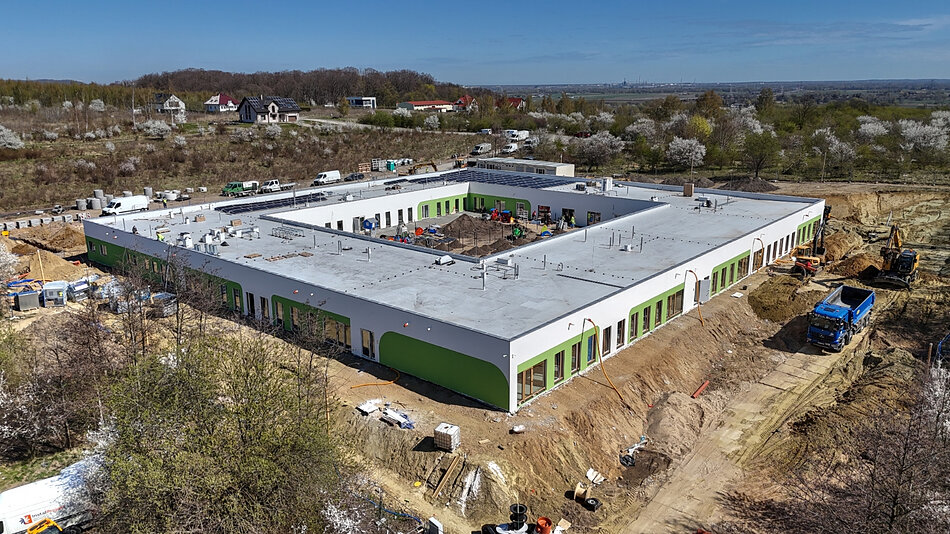 zdjęcie z drona, widać nowy budynek żłobka w kształcie kwadratu, wewnątrz z patio