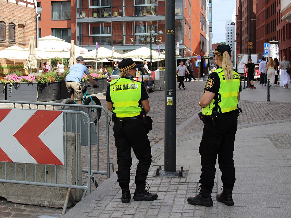 Dwie strażniczki miejskie na patrolu na ulicy miasta.