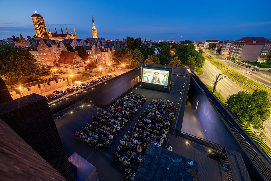 Widok kina plenerowego na dachu Teatru Szekspirowskiego. W tle panorama Gdańska. 