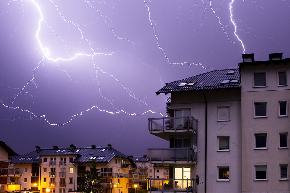 Błyskawice nad budynkami mieszkalnymi.
