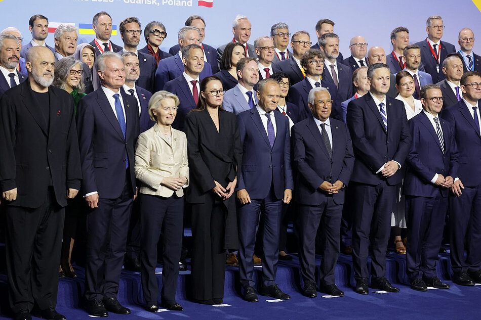 Zdjęcie dużej grupy osób pozujących do zdjęcia, pośrodku Donald Tusk