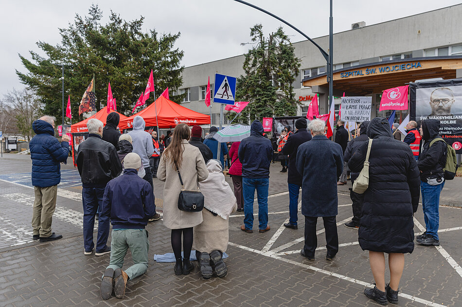 na zdjęciu kilka protestujących osób, w tym kilka osób klęczy 
