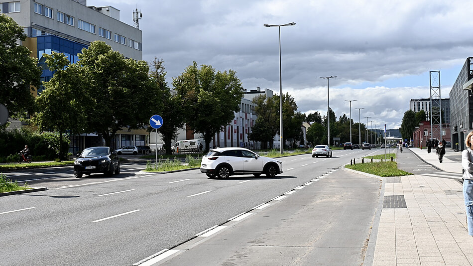 na zdjęciu kilkupasmowa jezdnia, widać kilka samochodów korzystających z tak zwanej nawrotki, zmieniających kierunek jazdy