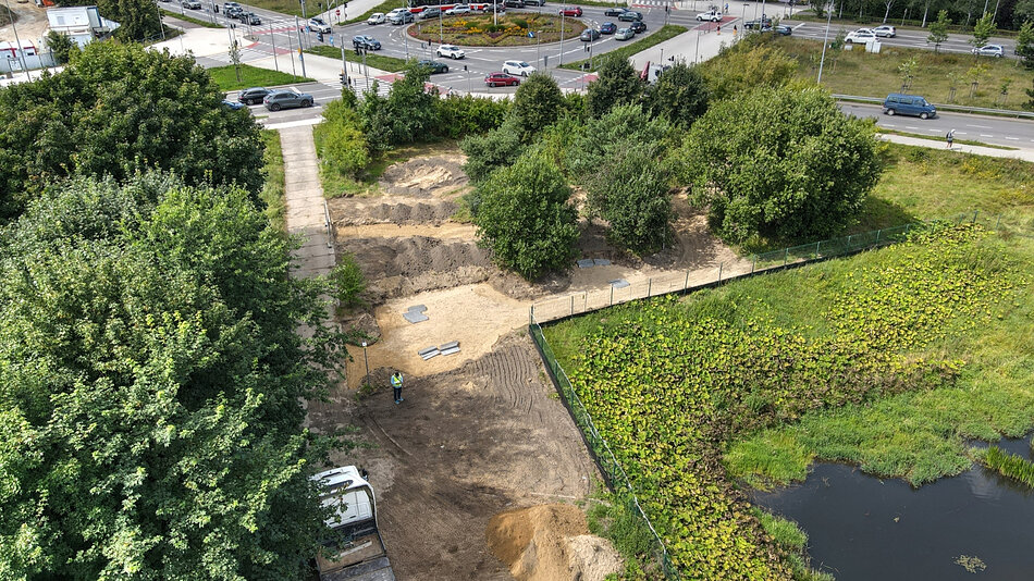 zdjęcie z drona, widać zielony teren, drzewa i rozkopany grunt