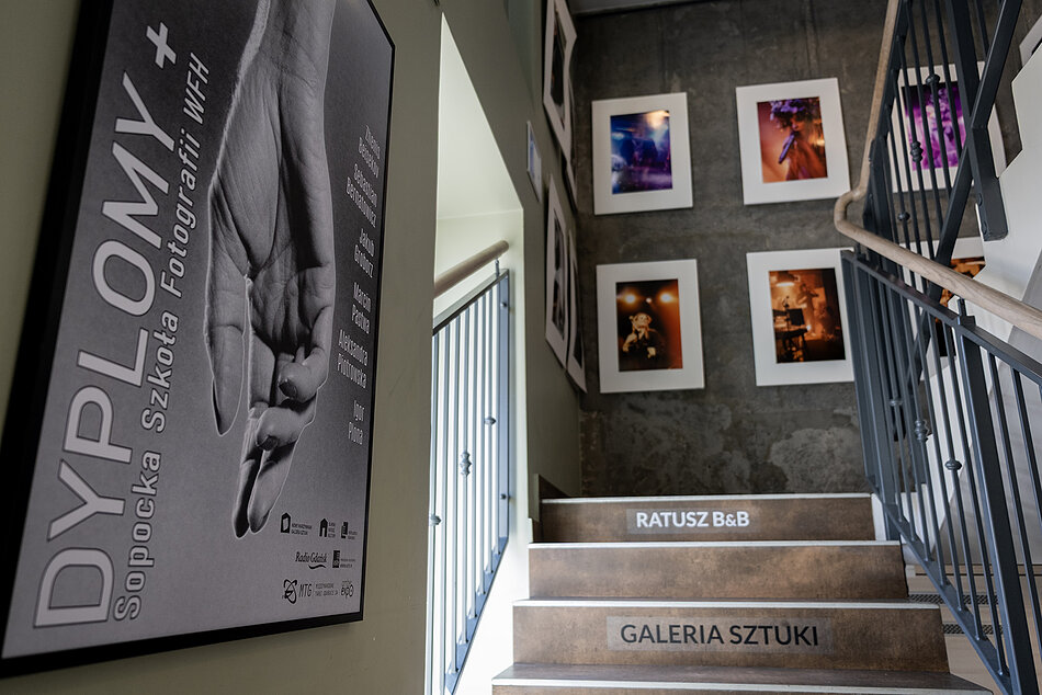 Plakat i wydruki fotografii na ścianach w galerii.