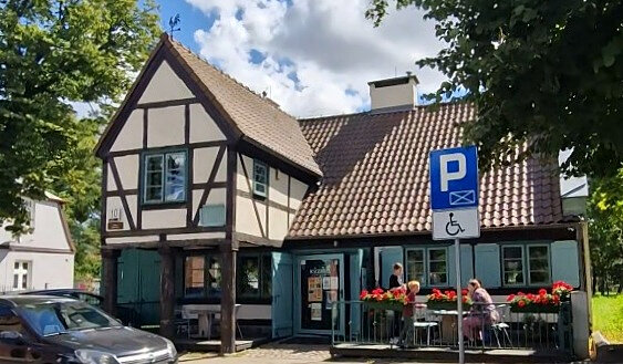 Widok na Kawiarnie, przy stoliku w ogródku siedzą ludzie