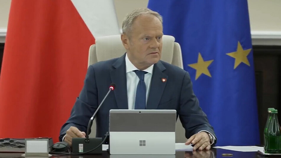 Premier Tusk na tle flagi RP i flagi UE