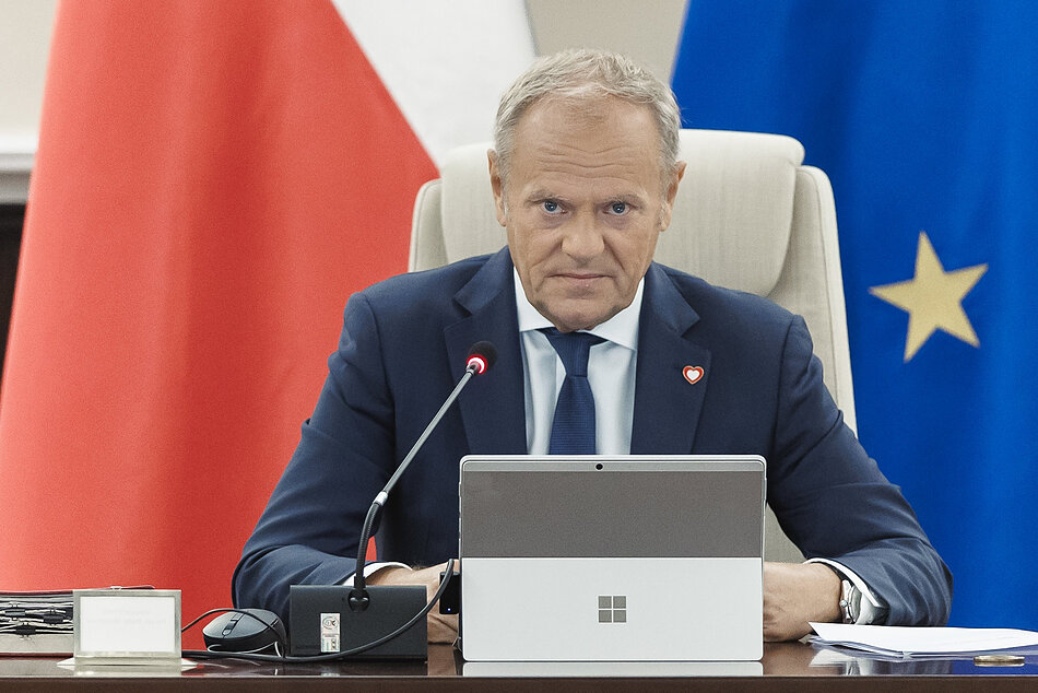 Premier Tusk na tle flagi RP i flagi UE