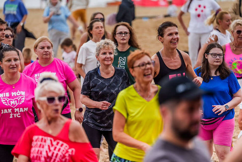 tłum kobiet w różnym wieku w strojach sportowych na plaży