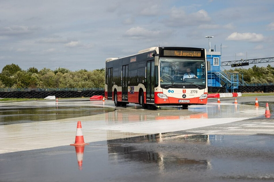 autobus jedzie po autodromie, po śliskiej nawierzchni
