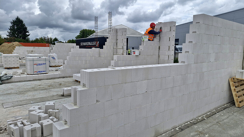 plac budowy, widać powstający budynek, układane są ściany z białych cegieł