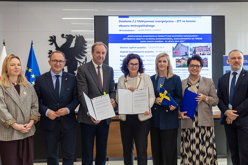 Zdjęcie grupowe podczas konferencji dotyczącej projektu „Kompleksowa modernizacja budynków mieszkalnych i użytkowych zlokalizowanych na terenie Gminy Miasta Gdańska”