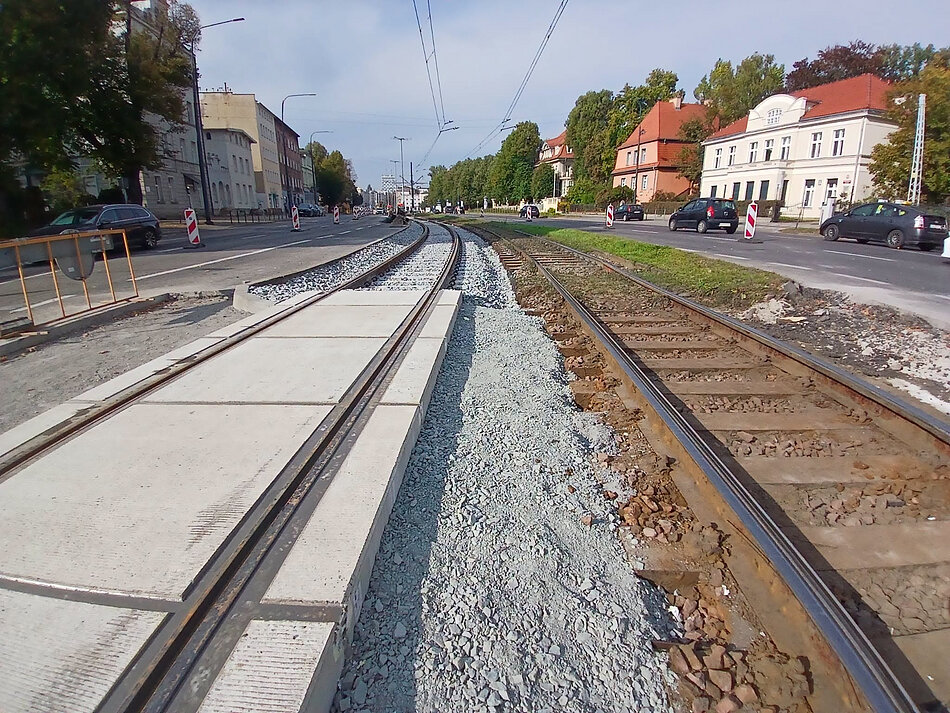 na zdjęciu po lewej wyremontowane betonowe torowisko tramwajowe, po prawej jeszcze stare wysłużone z drewnianym podkładem