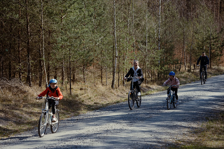 leśna droga rowerowe, na rowerze jedzie czteroosobowa rodzina