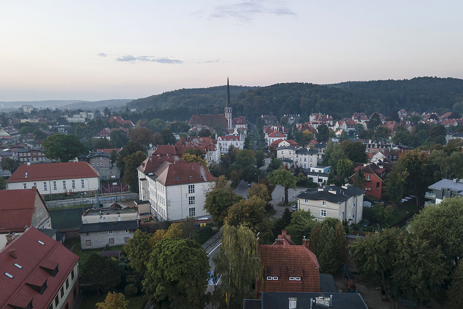 Widok z lotu ptaka na miasto, las i wzgórza morenowe.